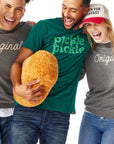 Man in Pickle Pickle Tee holding Chick-fil-A Nugget Pillow with one man on his one side and one woman on his other side