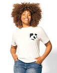 Woman with brunette hair standing wearing Cow Print Pocket Tee