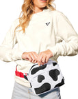 Woman with blonde hair wearing Lightweight Cow Pullover and Cow Print Belt Bag as fanny pack.