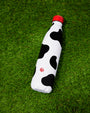 Black and white cow print Insulated Water Bottle with red lid shown on green turf