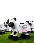 Multiple black and white plush stuffed cows with decorative felt sign on their back that says “Eat Mor Chikin”