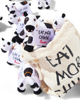 Closeup of several mini plush cows with a bag displaying their "Eat Mor Chikin" message from the Shareable Bag of Cows set