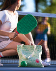 Woman on a pickleballcourt with Pickle Pickle™ Pickleball Set including the pickleball paddle, tote bag, and ball
