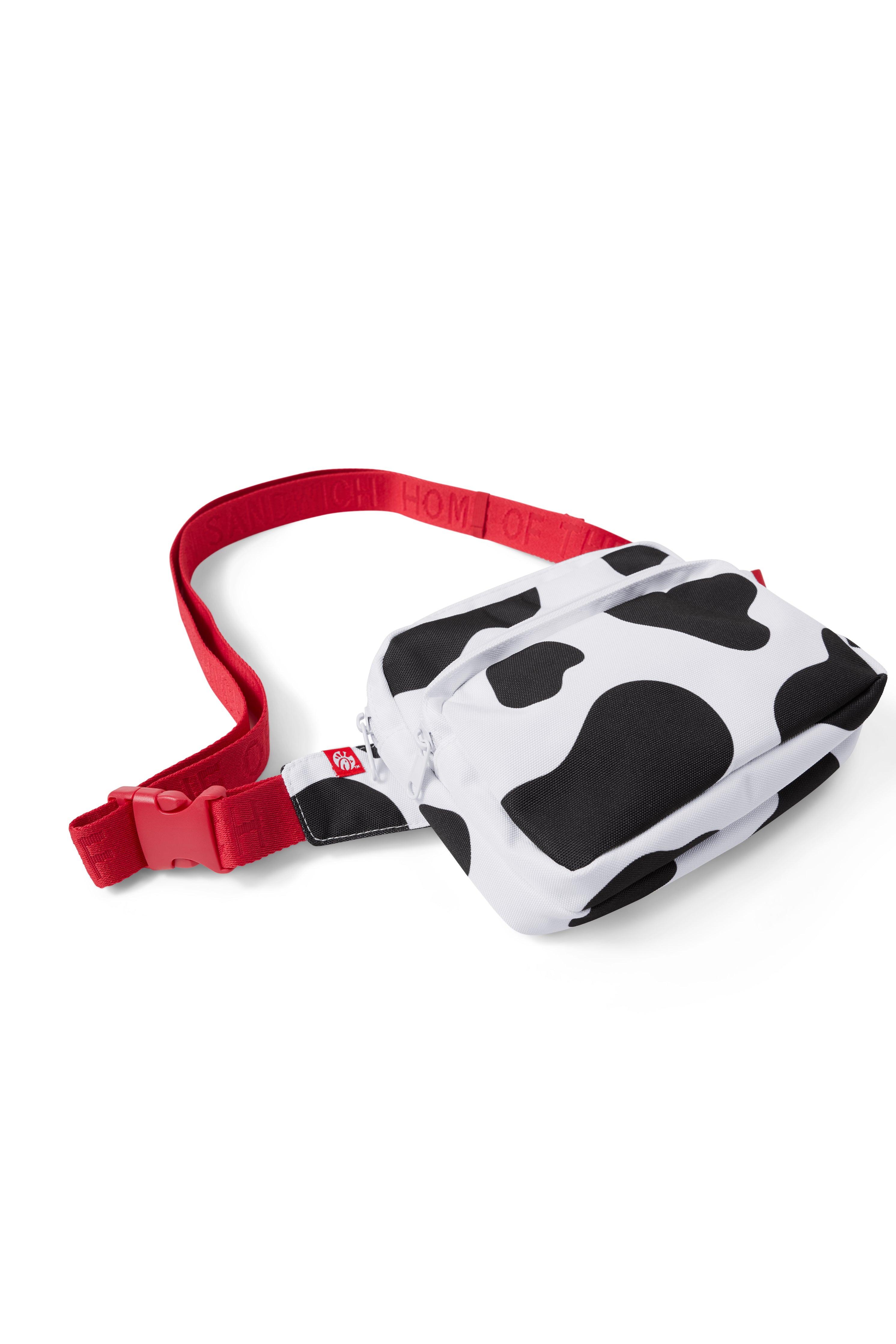 Overhead photograph of black and white Cow Print Belt Bag with red strap