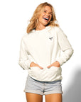 Woman with blonde hair standing wearing Lightweight Cow Pullover hoodie with hands in pockets