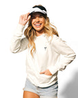 Woman with blonde hair standing wearing Lightweight Cow Pullover hoodie and Adjustable Cow Print Visor