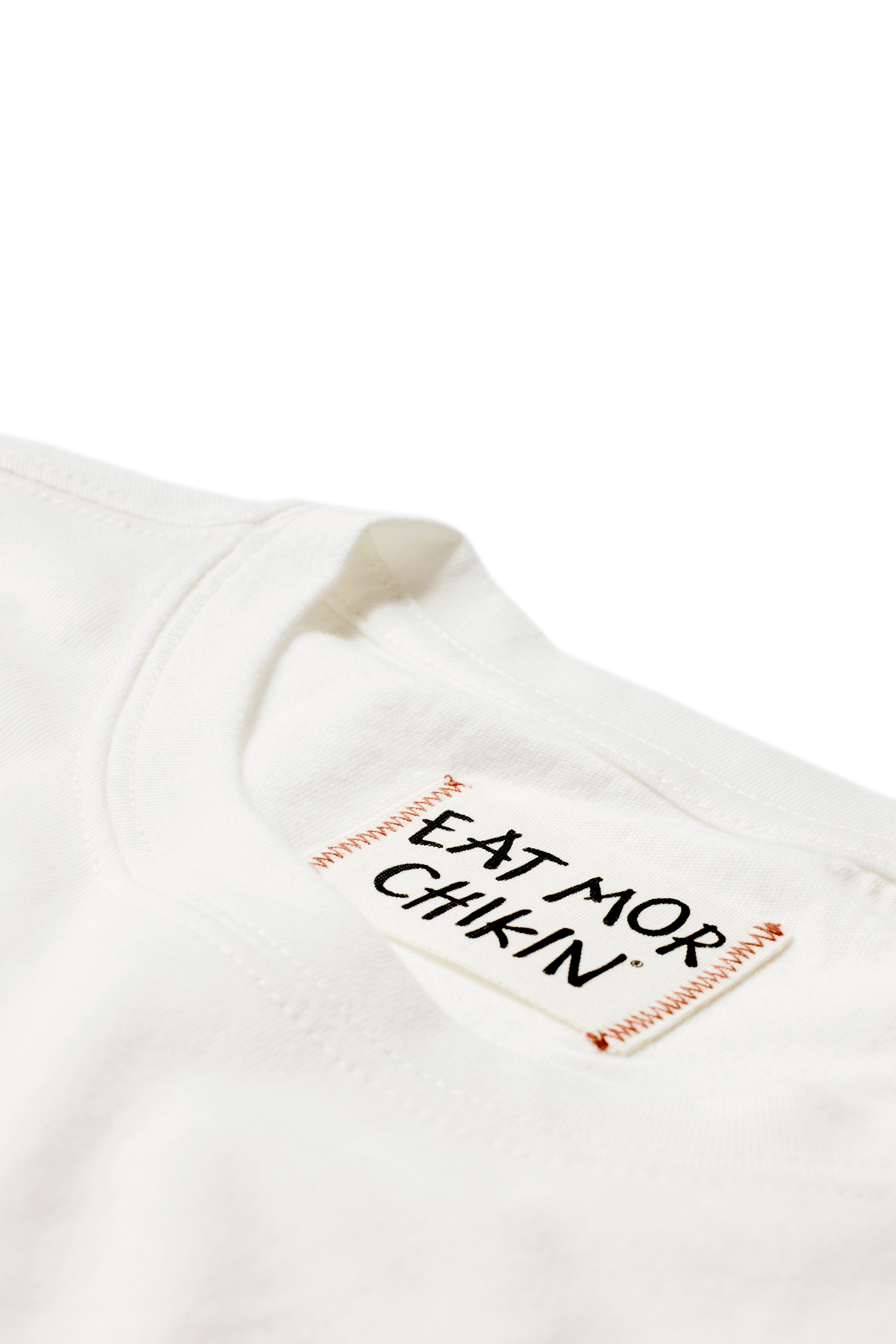 Closeup of &quot;Eat Mor Chikin&quot; tag on Cow Print Pocket Tee