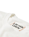 Closeup of "Eat Mor Chikin" tag on Cow Print Pocket Tee