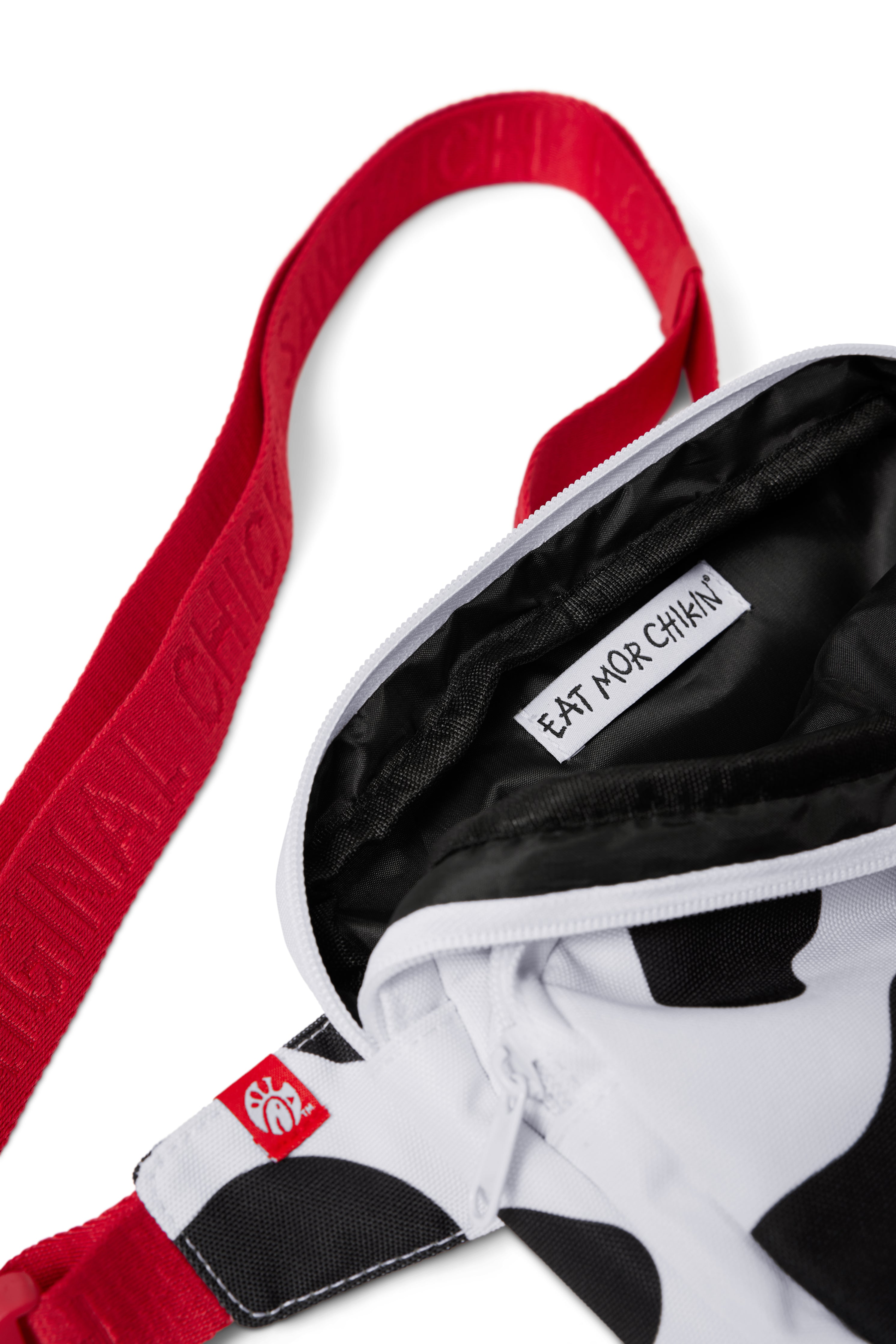 Close-up photograph of black interior of black and white Cow Print Belt Bag with red strap