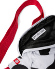 Close-up photograph of black interior of black and white Cow Print Belt Bag with red strap