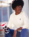 Woman wearing Embroidered Cow Crewneck and holding Cow Print Nalgene