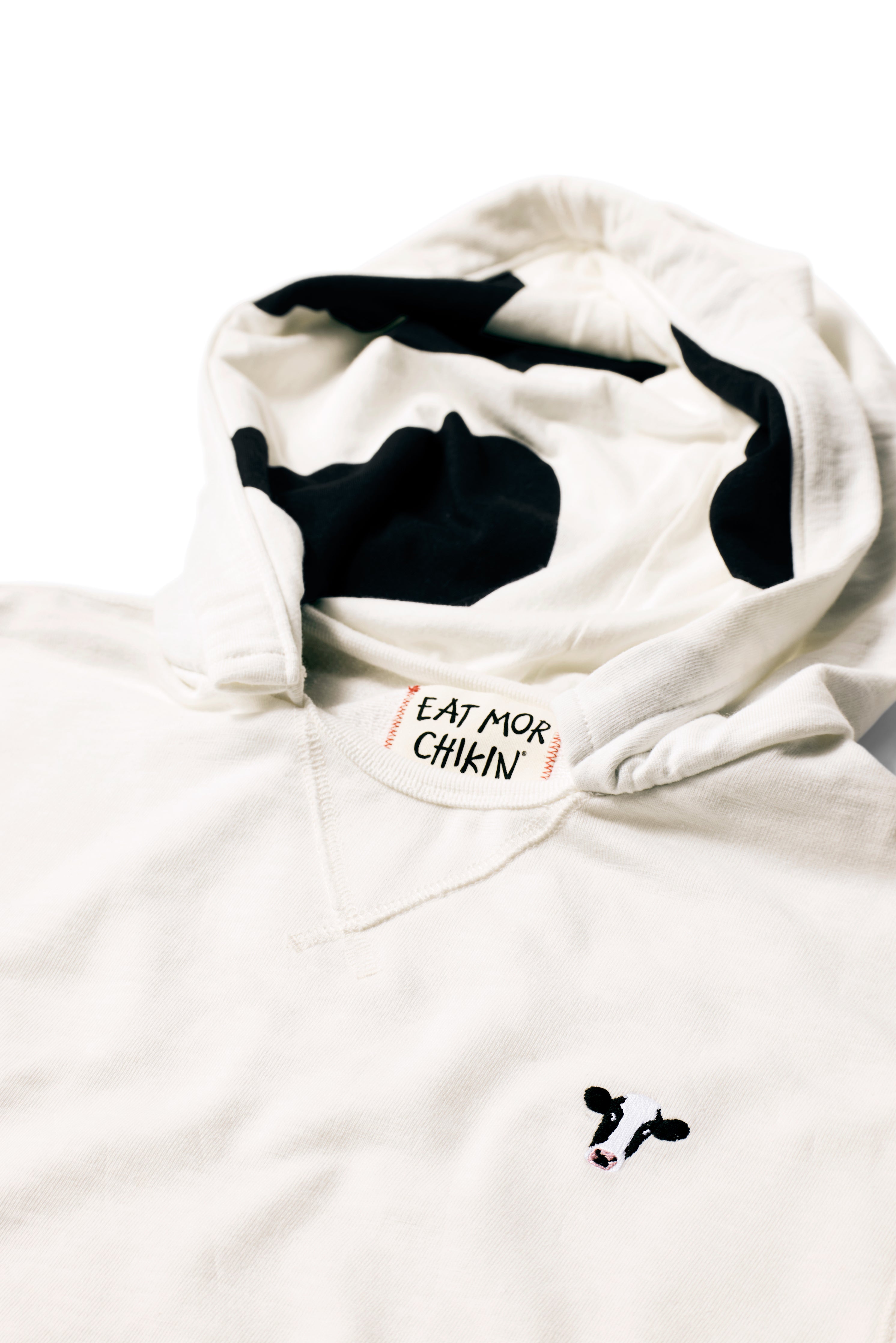 Closeup of cow head embroidery and cow print hood on Lightweight Cow Pullover