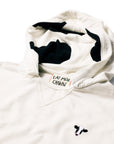 Closeup of cow head embroidery and cow print hood on Lightweight Cow Pullover