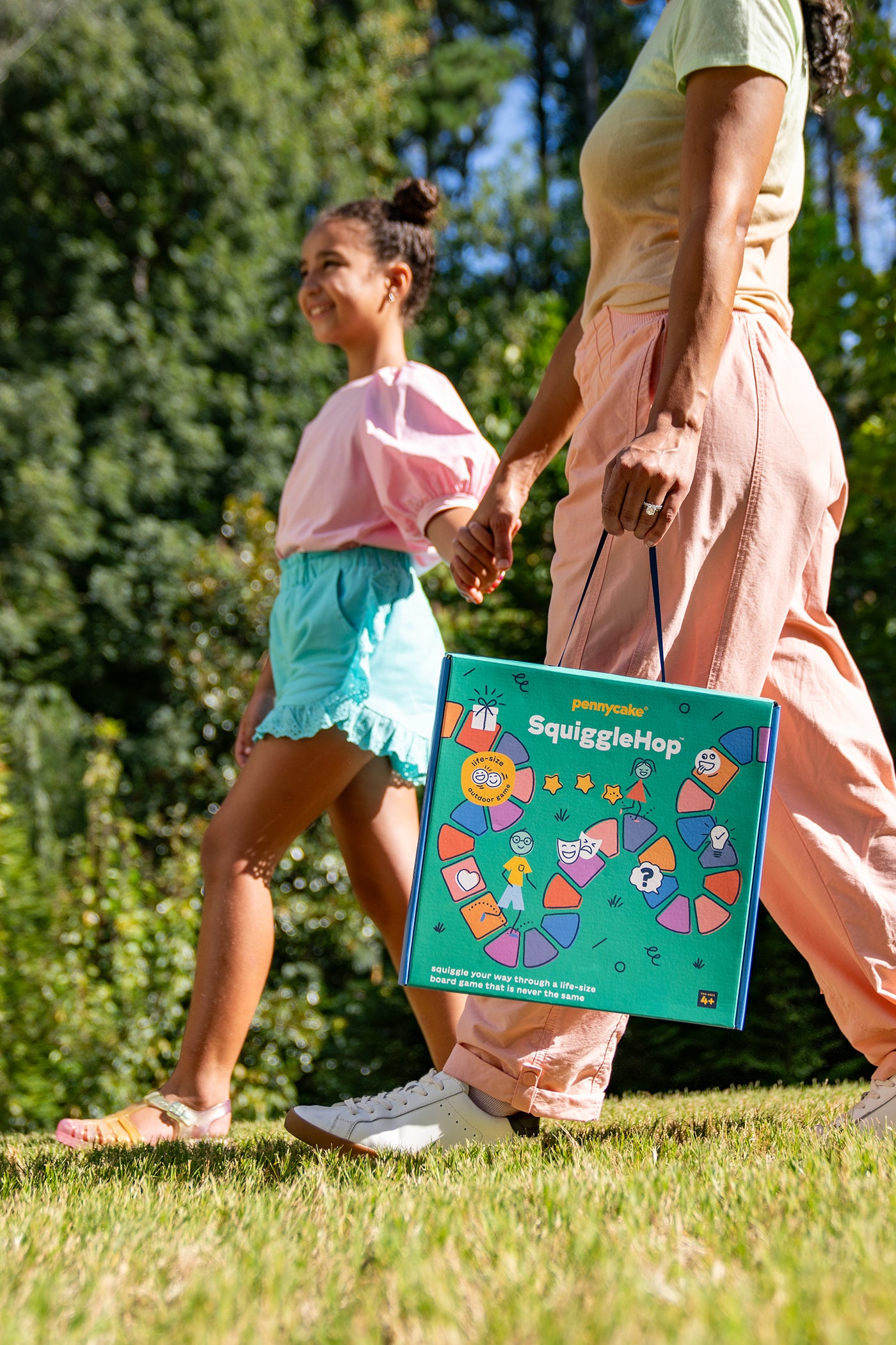 SquiggleHop™ Life-size Board Game - woman carrying board game and holding girl&#39;s hand - pennycake