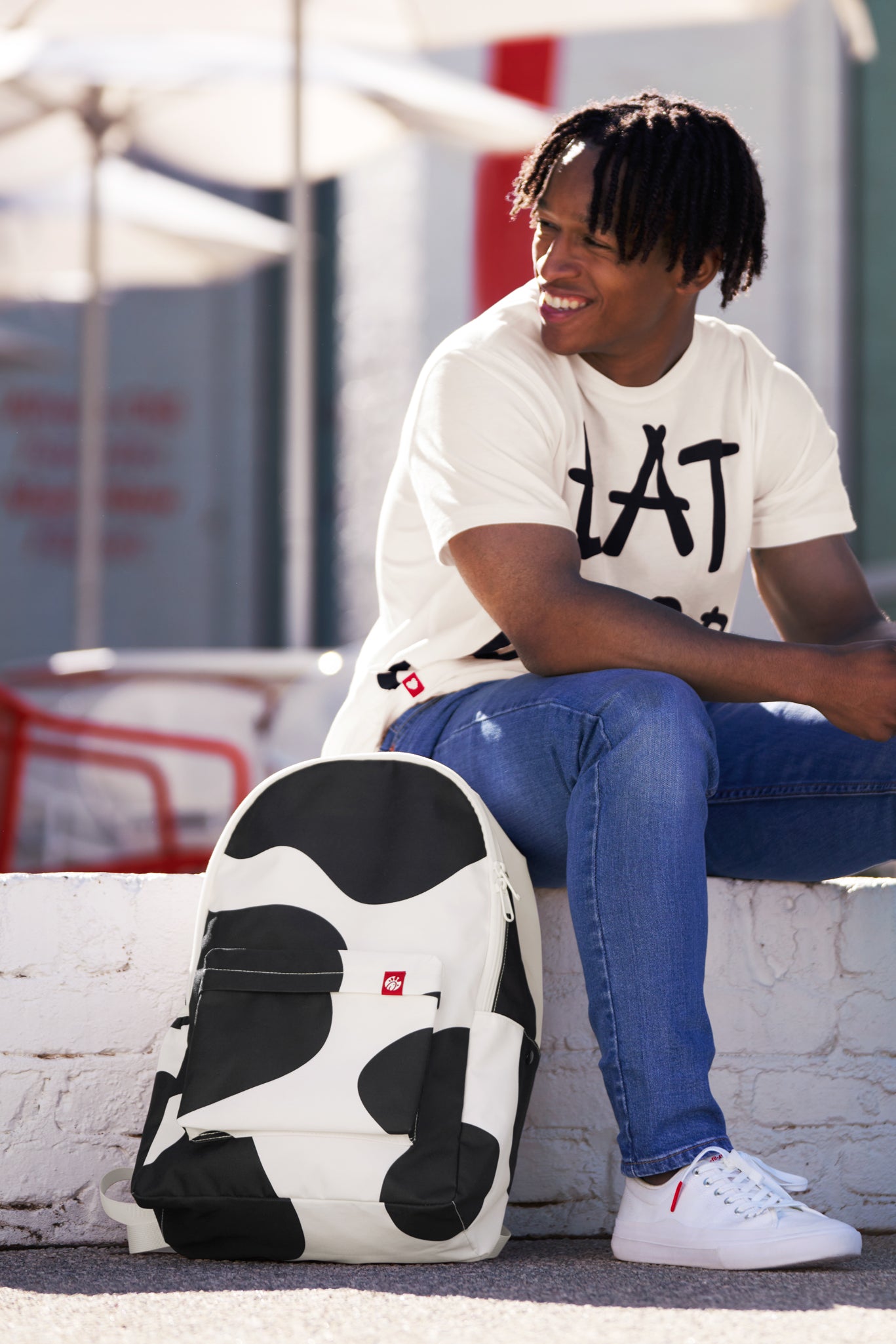 Man sitting with Cow Print Backpack