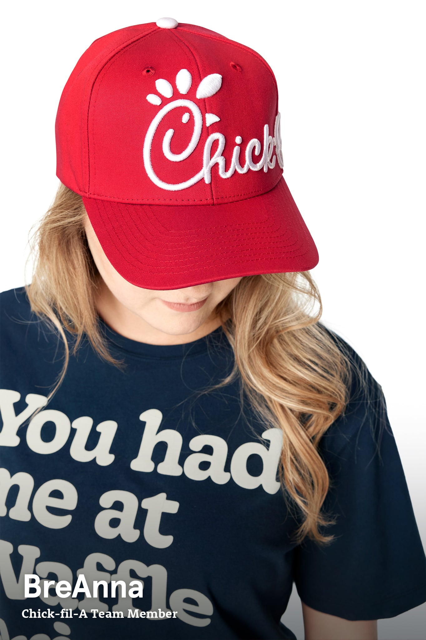 Woman wearing Classic Chick-fil-A Embroidered Hat looking down to show embroidery on hat