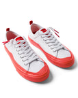 Pair of Dipped Kicks white shoes with red soles