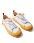 Pair of Dipped Kicks white shoes with yellow soles