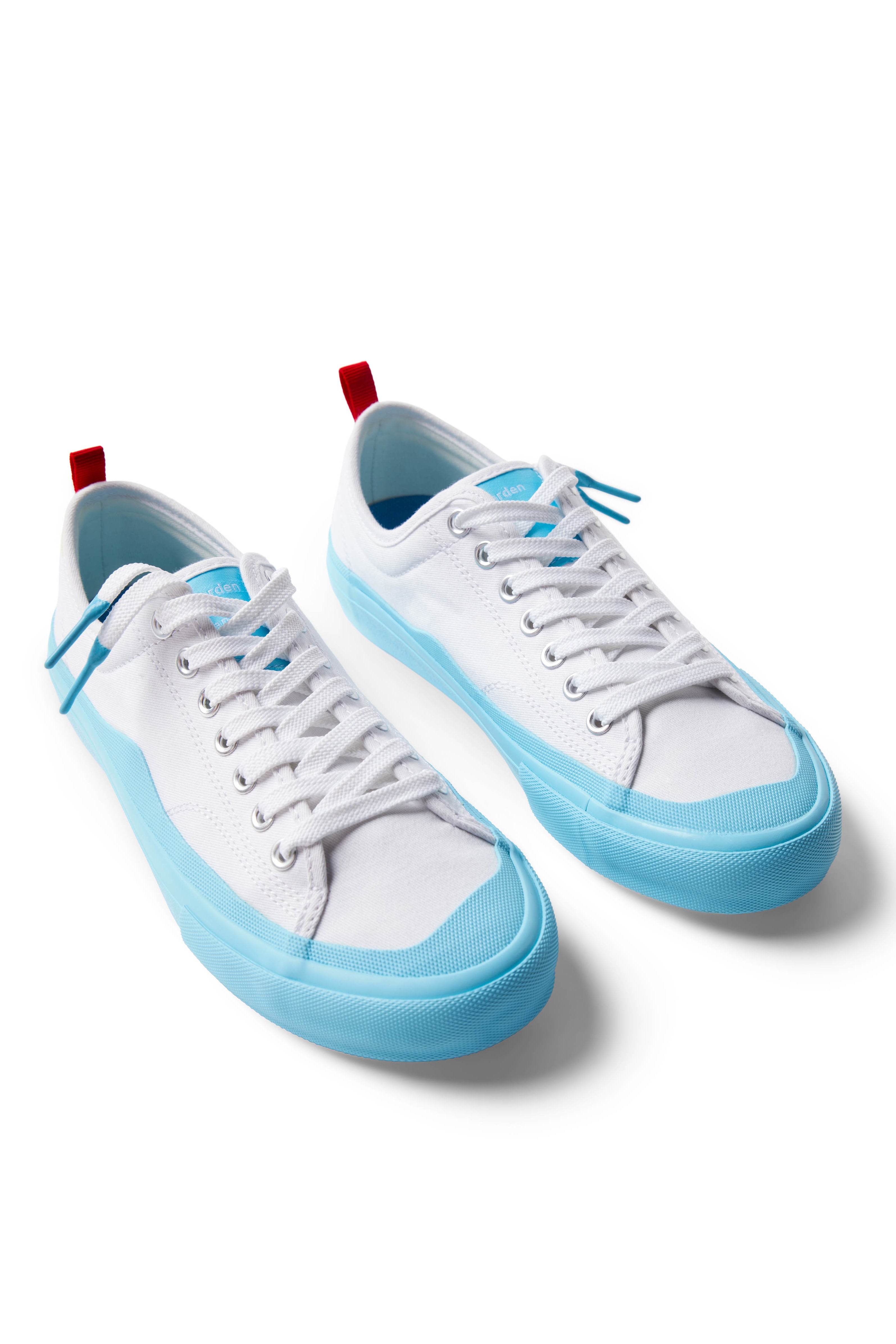 Pair of Dipped Kicks white shoes with blue soles