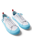 Pair of Dipped Kicks white shoes with blue soles