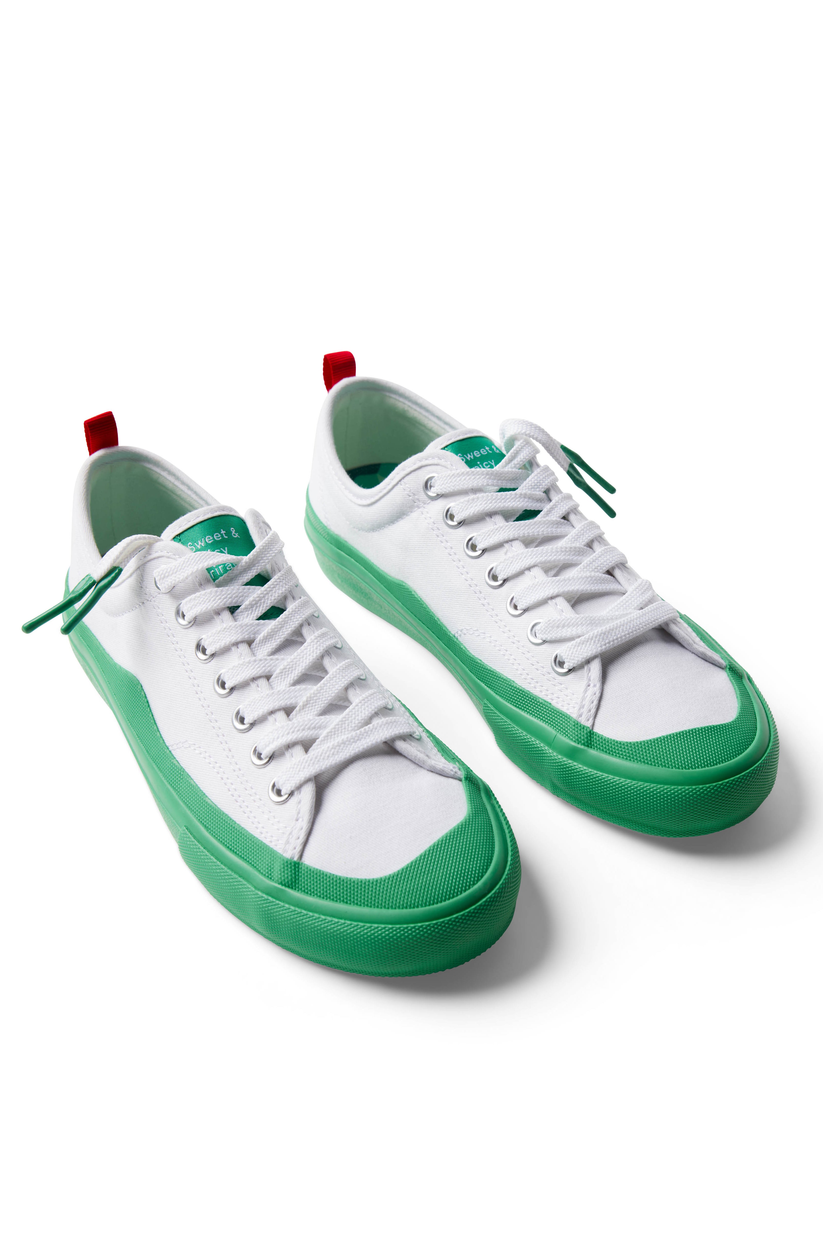 Pair of Dipped Kicks white shoes with green soles