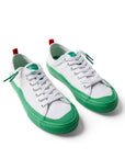 Pair of Dipped Kicks white shoes with green soles