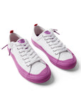 Pair of Dipped Kicks white shoes with purple soles