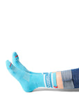 Pair of feet wearing blue socks with text "snappy & savory" above ankle on sock