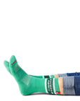 Pair of feet wearing green socks with text "sweet & spicy" above ankle on sock