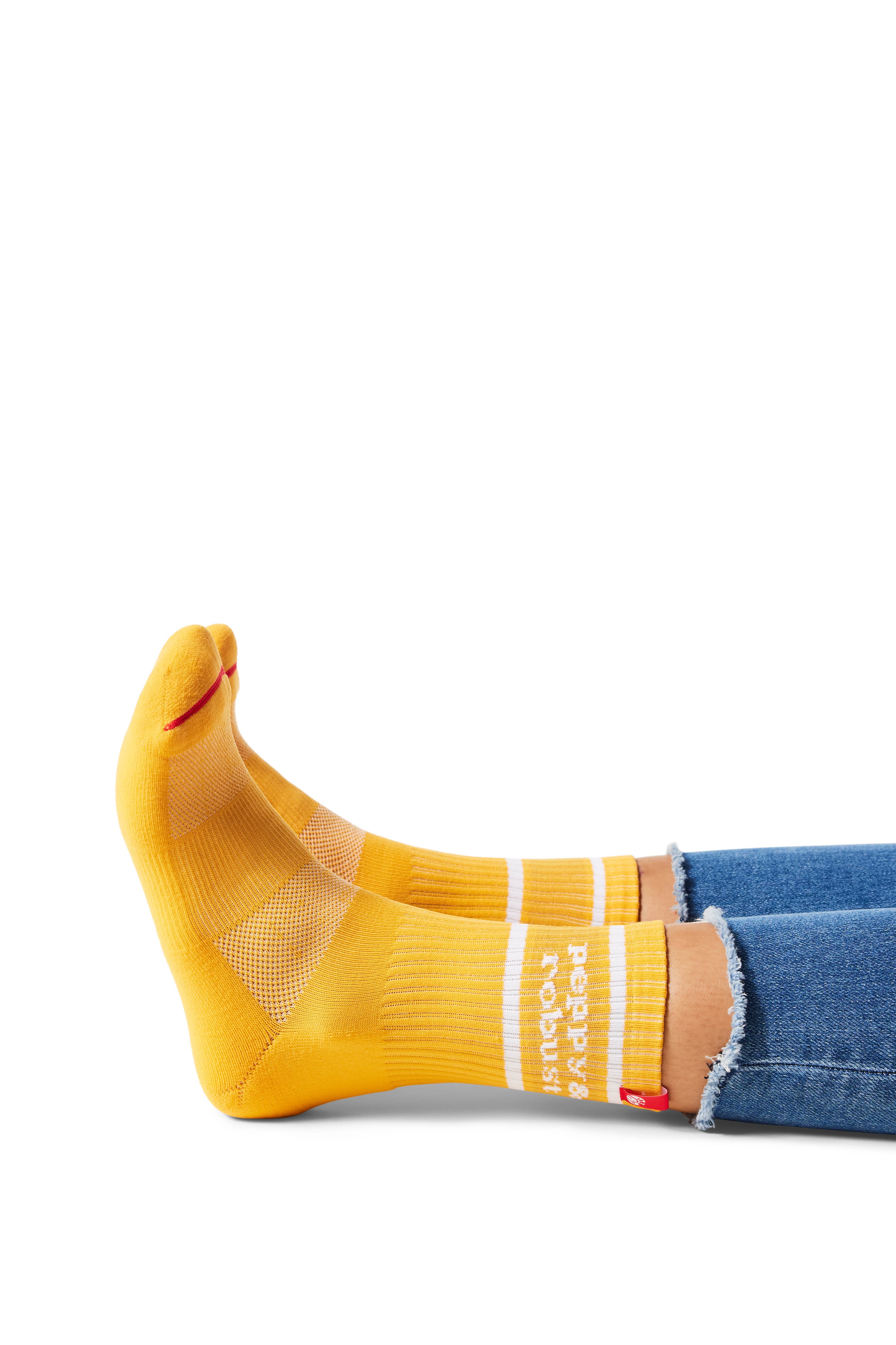 Pair of feet wearing yellow socks with text "peppy & robust" above ankle on sock