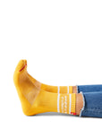 Pair of feet wearing yellow socks with text "peppy & robust" above ankle on sock