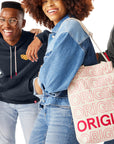 Woman holding Chick-fil-A™ Original Bucket Tote and standing with other men and women wearing Shop Chick-fil-A clothing