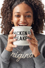 Girl wearing Original Crewneck holding Chicken for Breakfast Camper Mug up to her face