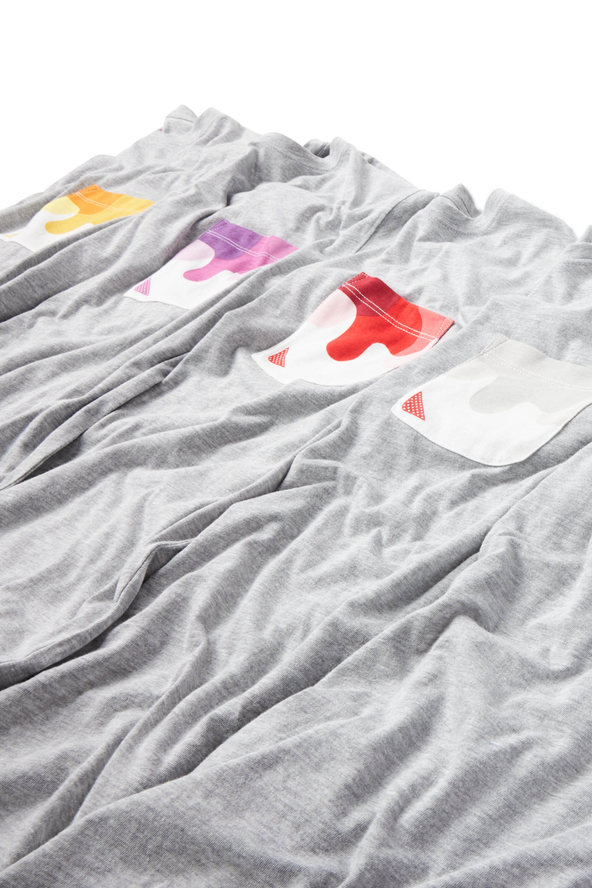 Gray Sauce Drip Pocket Tees laying in a row featuring yellow, purple, red, and gray pockets