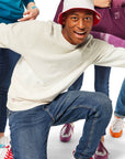 Man kneeling with arms out wearing Chick-fil-A Sauce Crewneck and Bucket Hat