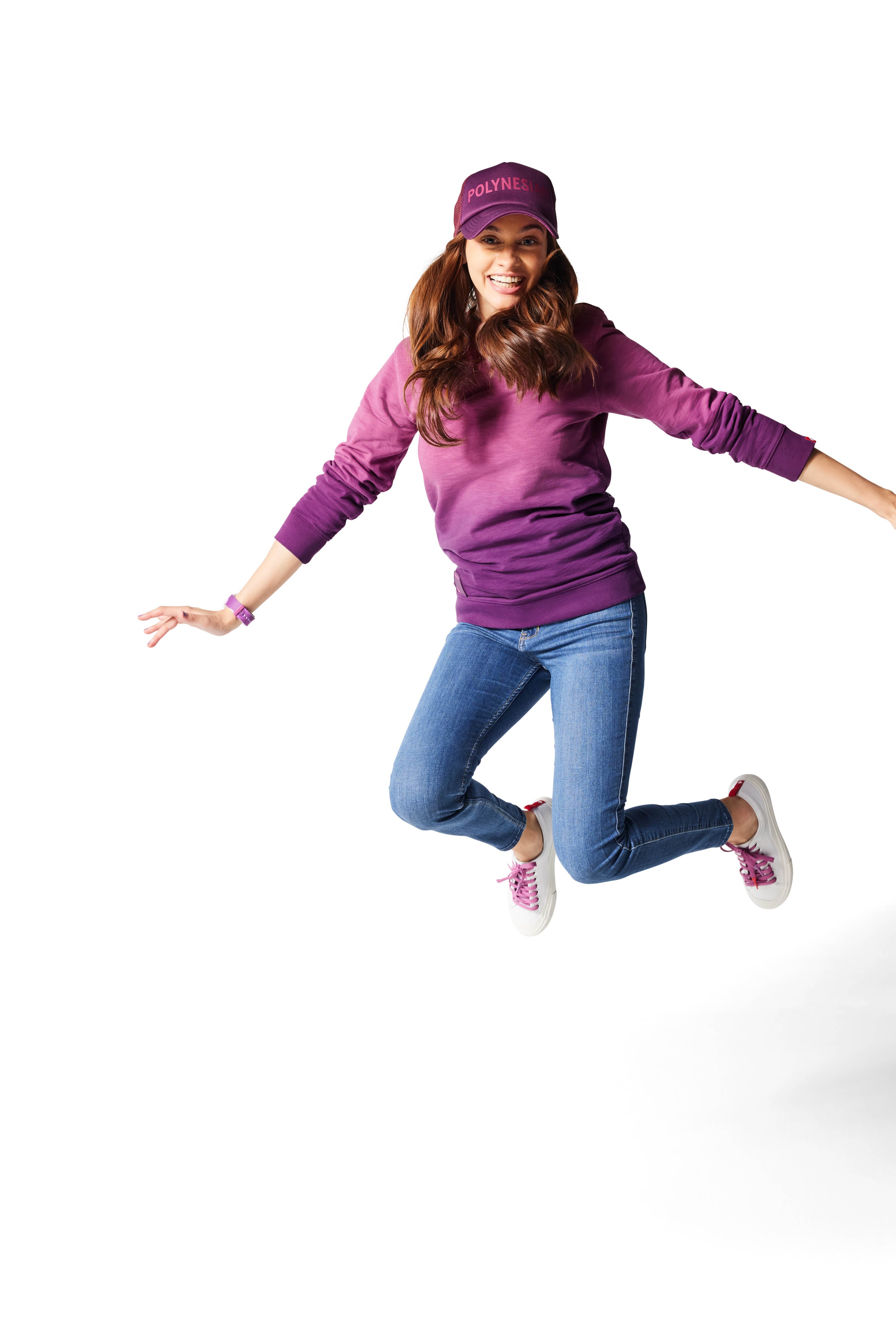 Woman jumping in air wearing purple Ombre Crewneck with purple Dipped Kicks shoes and purple Trucker Hat