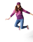 Woman jumping in air wearing purple Ombre Crewneck with purple Dipped Kicks shoes and purple Trucker Hat