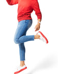 Woman jumping in air wearing red Ombre Crewneck with red Dipped Kicks shoes