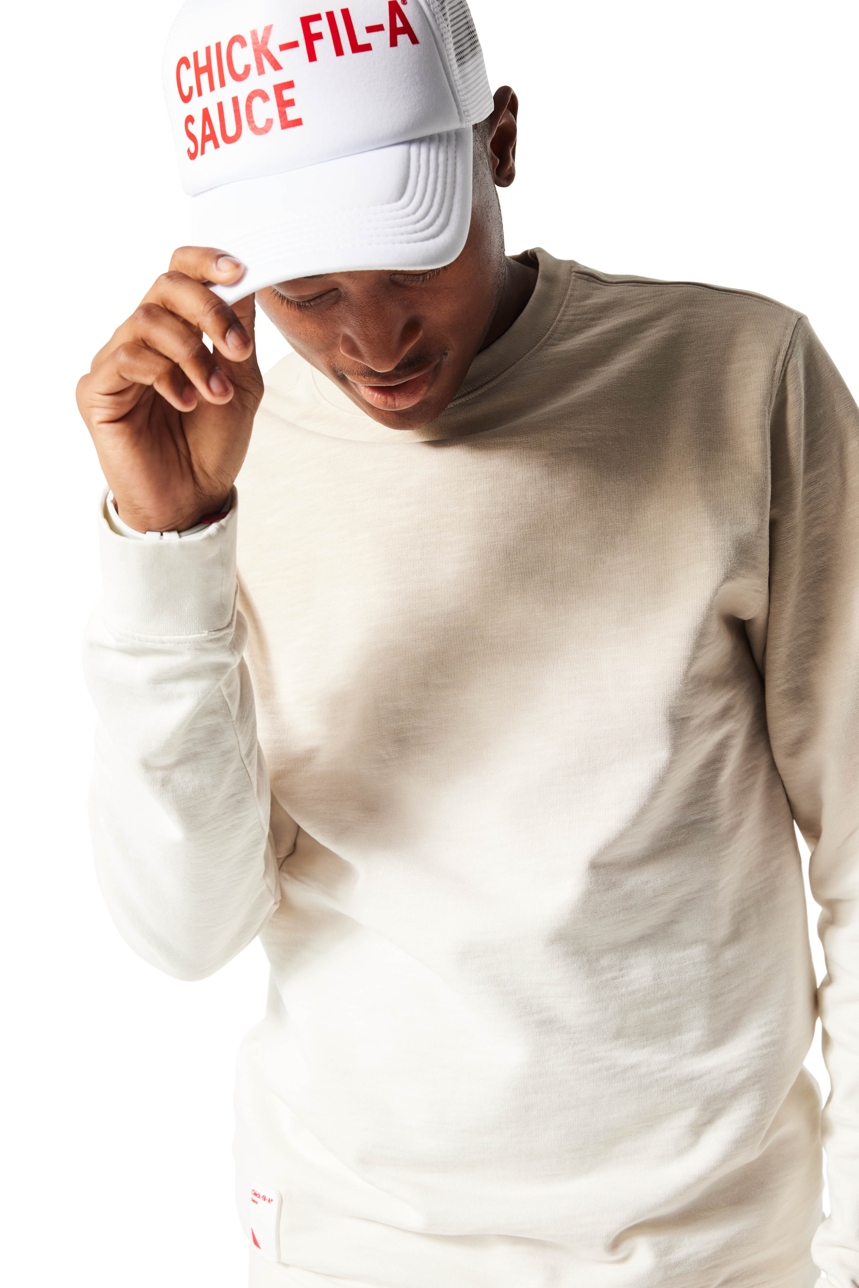 Closeup of man wearing white Trucker Hat with Chick-fil-A Sauce printed in red