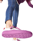 Shoe raised in mid-air displaying purple/Polynesian Sauce Dipped Kicks shoe tread with sauce packet dot pattern