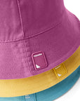 Closeup of yellow, gray/white, purple, and blue stack of Reversible Bucket Hats