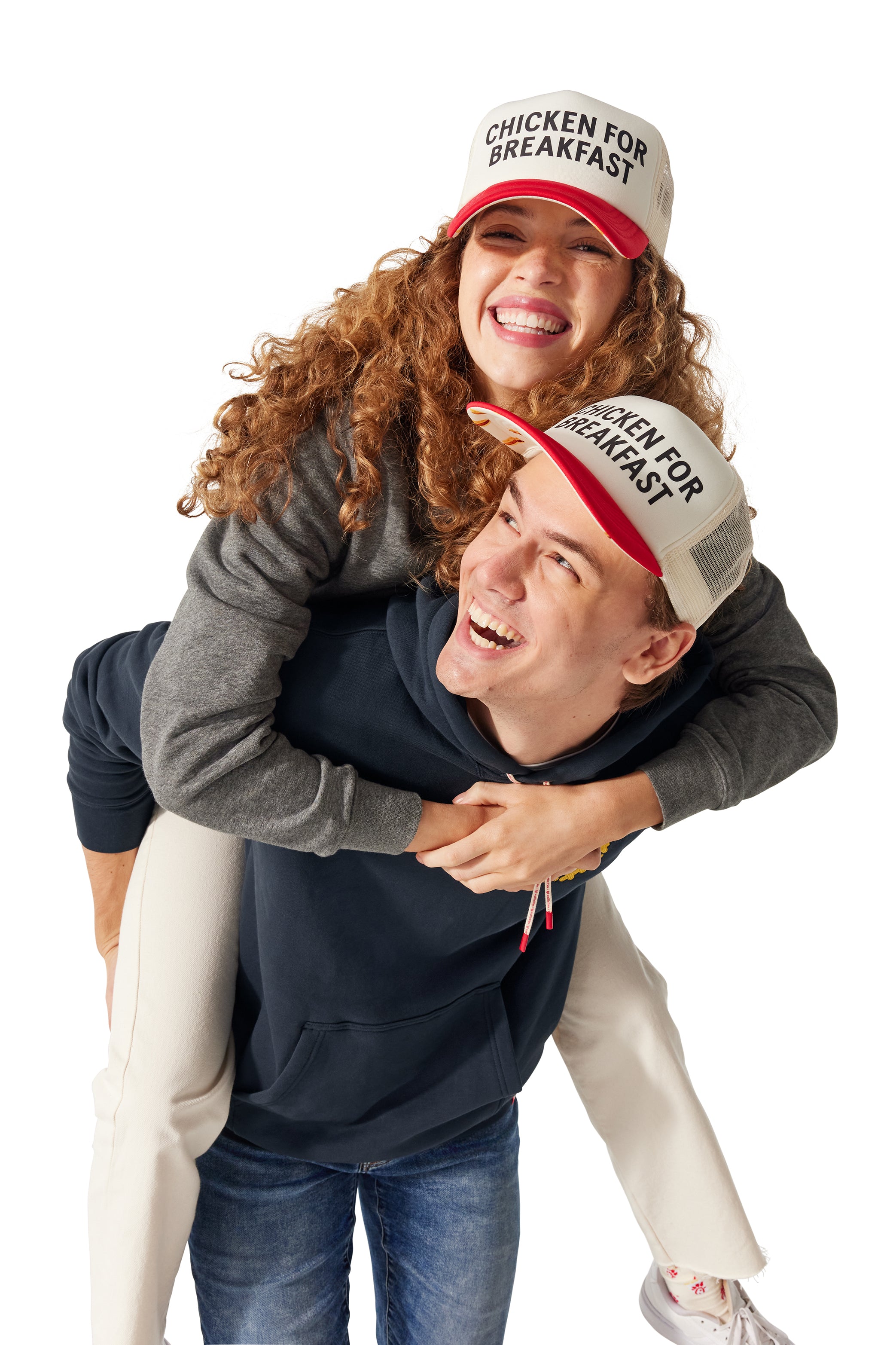 Woman wearing Original Crewneck and Chicken for Breakfast Trucker Hat on the back of man wearing I Heart Waffle Fries Hoodie and Chicken for Breakfast Trucker Hat