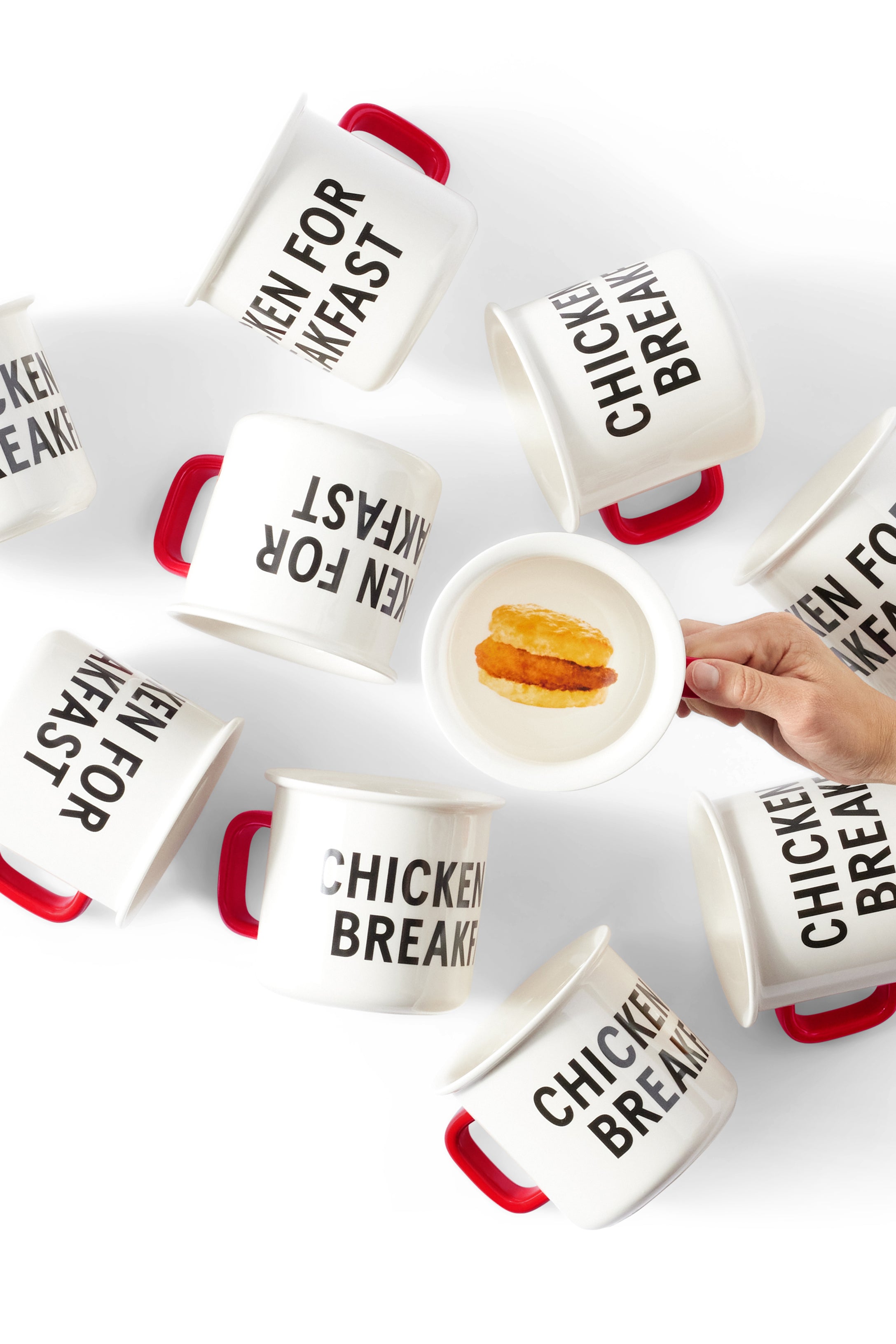 Overhead photograph of person holding Chicken for Breakfast Camper Mug and several other Chicken for Breakfast Camper Mugs laid on their sides