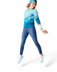 Woman jumping in air wearing blue Ombre Crewneck with blue Dipped Kicks and blue Trucker Hat