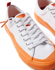 Pair of Dipped Kicks white shoes with orange soles