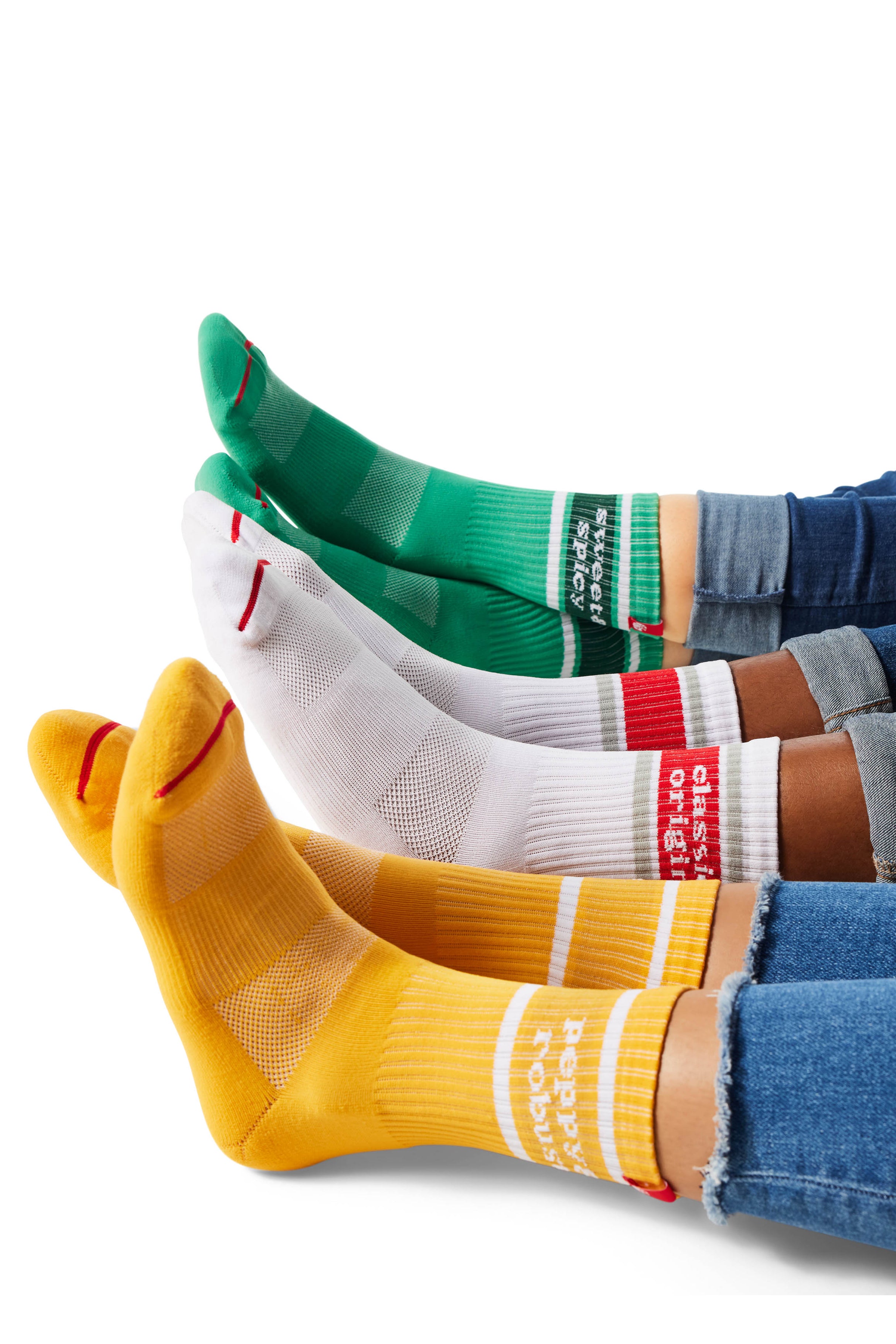 Three pairs of feet wearing yellow, red/white, and green socks