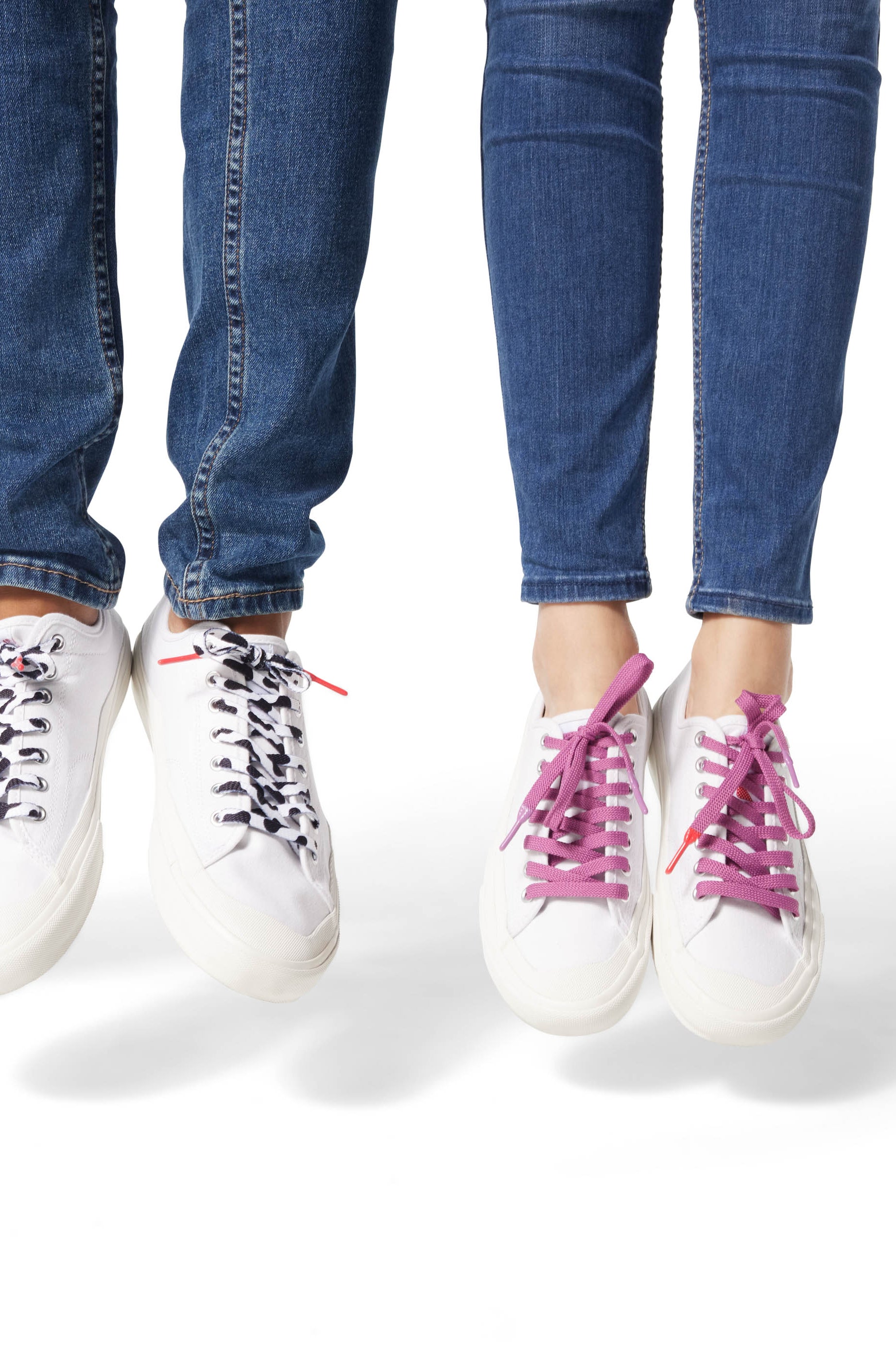 Two sets of Dipped Kicks shoes jumping in mid air displaying Sauce Shoelaces in purple and cow print