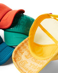 Several Trucker Hats including orange/ Buffalo, blue/Ranch, green, and yellow hat flipped over with logo printed under bill