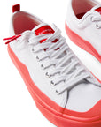 Pair of Dipped Kicks white shoes with red soles