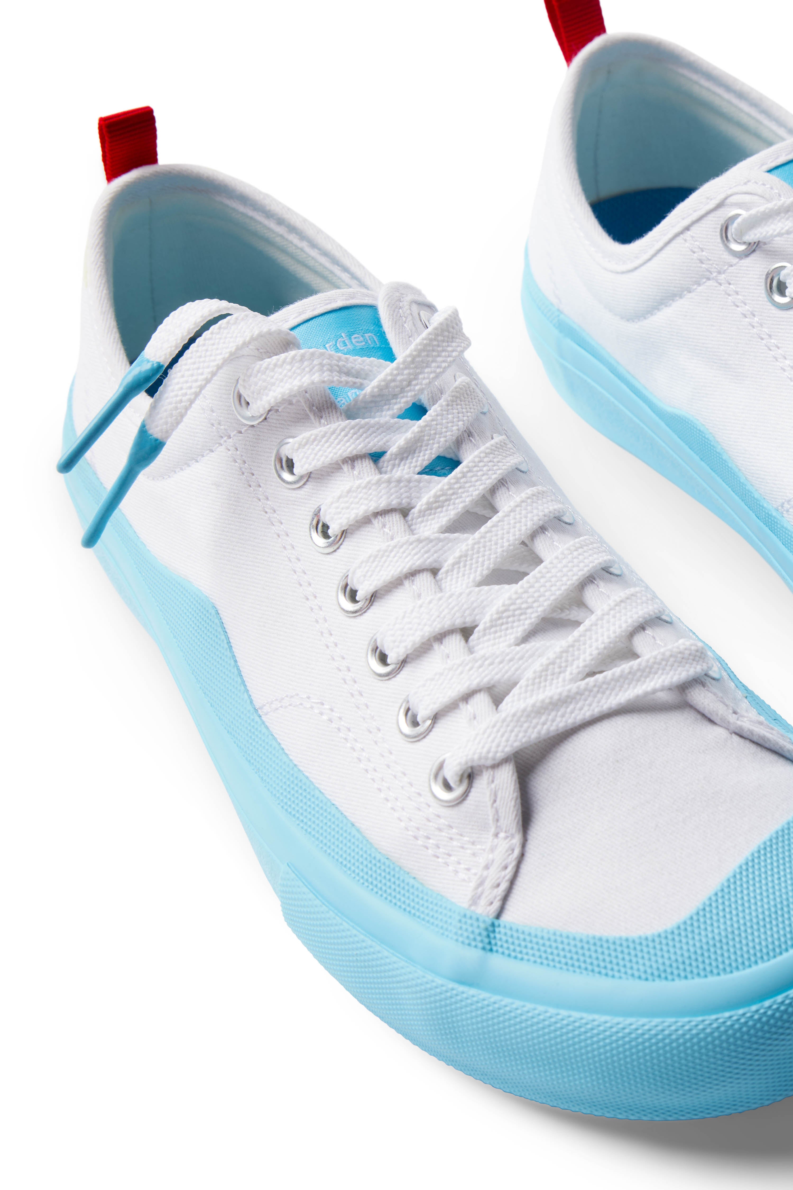 Pair of Dipped Kicks white shoes with blue soles